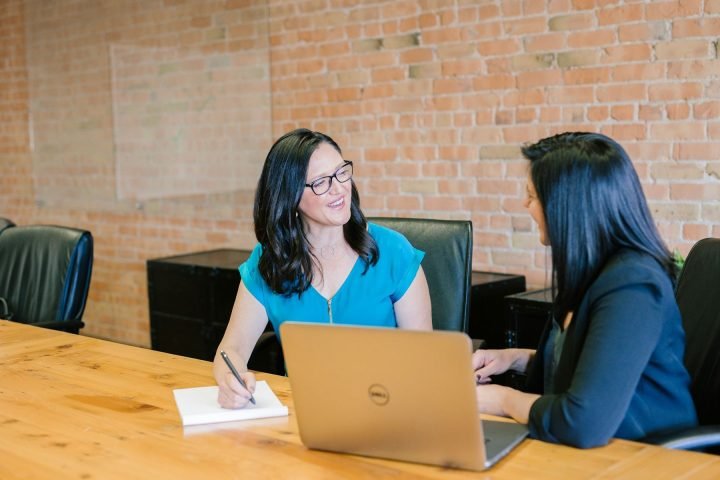 Two women talking across a table during an interview