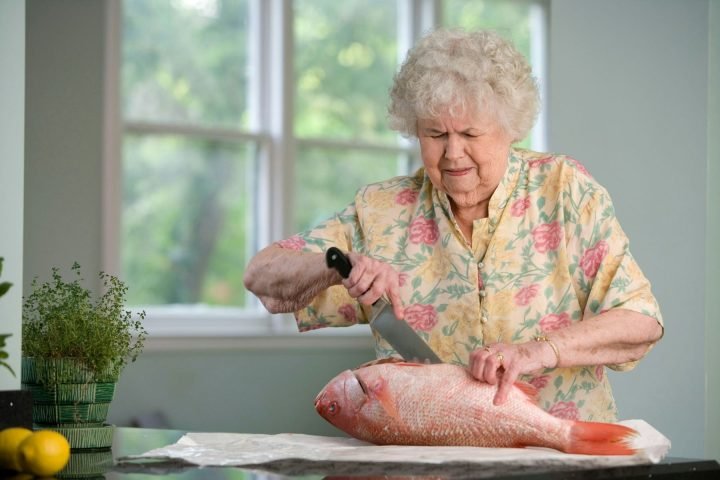 Older woman preparing a meal in her own kitchen