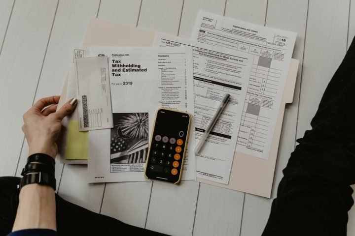Household forms, bills and a calculator spread on a table